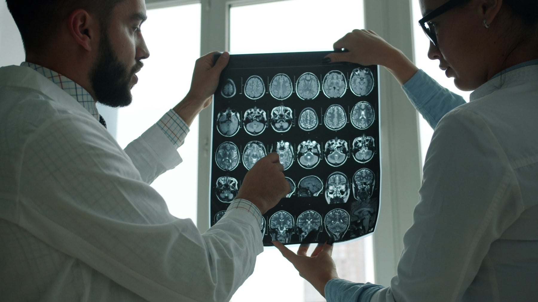 Two physicians looking at a brain MRI image together